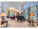 Elegant living room showcasing a grand piano, chandelier, and large windows with patterned curtains at 3343 W 109Th Cir, Westminster, CO 80031