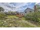 Backyard with a wooden deck attached to the house, lawn, and mature trees at 1758 S Ensenada St, Aurora, CO 80017