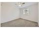 A bright bedroom with neutral carpet and walls; a window and ceiling fan provide comfort at 1758 S Ensenada St, Aurora, CO 80017