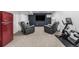 Carpeted basement with a unique red refrigerator, comfortable recliners, and exercise equipment at 2650 S Vaughn Way # D, Aurora, CO 80014