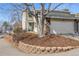 Inviting two-story home featuring a stone accent garage, lush landscaping, and covered porch at 2650 S Vaughn Way # D, Aurora, CO 80014