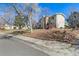 The house is a multi-story building on a corner lot with green space and mature trees at 2650 S Vaughn Way # D, Aurora, CO 80014