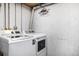 Functional laundry area with washer, dryer, and unfinished walls at 2650 S Vaughn Way # D, Aurora, CO 80014