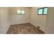Simple bedroom featuring wood-look floors, white walls, and natural light from windows at 2809 Yates St, Denver, CO 80212