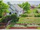 Charming home showcasing a lush yard with raised garden beds and a stairway to the front door at 2809 Yates St, Denver, CO 80212