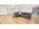 A comfortable living area in the finished basement with a gray sofa and wood-look flooring at 742 Norwich Ct, Castle Pines, CO 80108