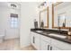 Contemporary bathroom showcasing double sinks with black countertops and modern rustic wood-framed mirrors at 742 Norwich Ct, Castle Pines, CO 80108