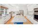 Spacious kitchen with white cabinetry, stainless steel appliances, and a large center island with granite countertop at 742 Norwich Ct, Castle Pines, CO 80108