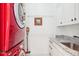 Convenient laundry room with a red washer/dryer set and storage cabinets at 742 Norwich Ct, Castle Pines, CO 80108