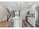 Modern kitchen with white cabinets, island, and a view from the kitchen to the stairs and back deck at 1435 W 68Th Ave, Denver, CO 80221