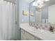 Cozy bathroom featuring white vanity with gold fixtures, matching pink tiled accent wall, and shower with curtain at 452 Deframe Ct, Golden, CO 80401