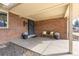 Inviting front porch with brick siding, a bench, decorative plants, and a covered entrance at 452 Deframe Ct, Golden, CO 80401