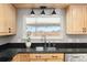 Kitchen sink and countertops with updated light fixtures and a view to the backyard at 452 Deframe Ct, Golden, CO 80401