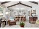Open-concept living and dining areas with exposed ceiling beams, modern light fixtures, and large windows at 452 Deframe Ct, Golden, CO 80401