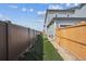 Townhouse backyard featuring artificial turf and side yards with wood and dark brown fencing at 608 N Bersshine Ct, Watkins, CO 80137
