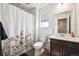 Full bathroom features a shower with floral curtain, a dark vanity, and a framed mirror at 608 N Bersshine Ct, Watkins, CO 80137