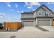 Gray townhouse with a two-car garage, concrete driveway, and a wooden fence at 608 N Bersshine Ct, Watkins, CO 80137