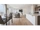 Open concept living space with hardwood floors, eat-in dining, dark leather sofas, and TV mounted to the wall at 608 N Bersshine Ct, Watkins, CO 80137