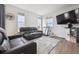 Cozy space featuring leather sofas, a TV and entertainment center, hardwood floors, and bright, sunlit windows at 608 N Bersshine Ct, Watkins, CO 80137