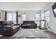 A modern living area featuring hardwood floors, a plush rug, neutral paint, and comfortable leather seating at 608 N Bersshine Ct, Watkins, CO 80137