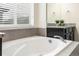 Bathroom featuring a relaxing soaking tub and updated vanity at 12243 Joplin St, Commerce City, CO 80603