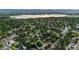 Aerial view of the neighborhood shows lush greenery, a lake, and mountain views in the distance at 4634 W Tufts Cir, Denver, CO 80236