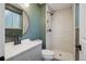 Bathroom boasts a round mirror, modern shower, and neutral color palette at 4634 W Tufts Cir, Denver, CO 80236