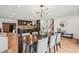 Open dining room showcases a large table, modern chandelier, and seamless flow to the kitchen at 4634 W Tufts Cir, Denver, CO 80236