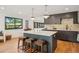 Modern kitchen with center island, hardwood floors, custom cabinetry, and stainless steel appliances at 4634 W Tufts Cir, Denver, CO 80236
