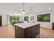 Open-concept kitchen featuring a large center island with seating and hardwood floors throughout at 4634 W Tufts Cir, Denver, CO 80236