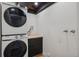 Efficient laundry area featuring a stacked washer and dryer, cabinet space, and utility connections at 4634 W Tufts Cir, Denver, CO 80236