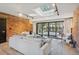 Bright living room features a brick accent wall, skylight, and sliding glass doors to the outdoor space at 4634 W Tufts Cir, Denver, CO 80236