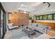 Bright living room with exposed brick accent wall, hardwood flooring, and a skylight at 4634 W Tufts Cir, Denver, CO 80236