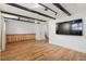 Bright living room with hardwood floors, TV, and dark wood beams with a built in cabinet at 4634 W Tufts Cir, Denver, CO 80236