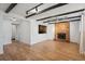 Living room with hardwood flooring, fireplace, and decorative ceiling beams at 4634 W Tufts Cir, Denver, CO 80236