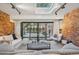 Bright living room featuring exposed brick walls, a skylight, and sliding doors to the outside patio at 4634 W Tufts Cir, Denver, CO 80236