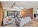 Bright living room with exposed brick wall, skylight, and open floor plan at 4634 W Tufts Cir, Denver, CO 80236