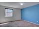 Bedroom with blue accent wall, carpet flooring, and large window at 5759 E Geddes Cir, Centennial, CO 80112