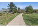 Backyard with a concrete path surrounded by a green lawn at 762 Hughes Ln, Highlands Ranch, CO 80126