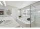 Bright bathroom with a soaking tub, separate shower, and dual sink vanity with tiled countertops at 762 Hughes Ln, Highlands Ranch, CO 80126