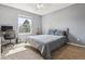 Well-lit bedroom with a neutral color scheme, desk, and natural light from a large window at 762 Hughes Ln, Highlands Ranch, CO 80126