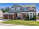 Charming two-story home featuring a brick and gray facade, a two-car garage, and a well-manicured front lawn at 762 Hughes Ln, Highlands Ranch, CO 80126