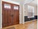 Elegant wood double doors with decorative glass accents, complemented by light hardwood flooring at 762 Hughes Ln, Highlands Ranch, CO 80126