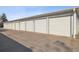 Row of garage spaces with white doors and a paved driveway at 750 S Clinton St # 6B, Denver, CO 80247