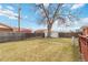 View of backyard with a wooden fence, shed, and grass at 6900 Avrum Dr, Denver, CO 80221