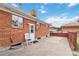 Brick exterior with a backyard patio area and white doors with the perfect blend of privacy and outdoor living at 6900 Avrum Dr, Denver, CO 80221
