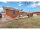 An inviting backyard featuring a patio, well-maintained lawn, and a classic brick house at 6900 Avrum Dr, Denver, CO 80221