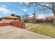An inviting backyard featuring a patio, well-maintained lawn, and a classic brick house at 6900 Avrum Dr, Denver, CO 80221