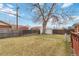 View of backyard with a wooden fence, shed, and grass at 6900 Avrum Dr, Denver, CO 80221