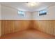 Unfinished basement area featuring wood paneling and small windows, ready for transformation at 6900 Avrum Dr, Denver, CO 80221